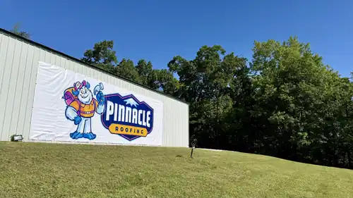 The Pinnacle Roofing & Siding headquarters building in Springdale with the current brand banner on the wall