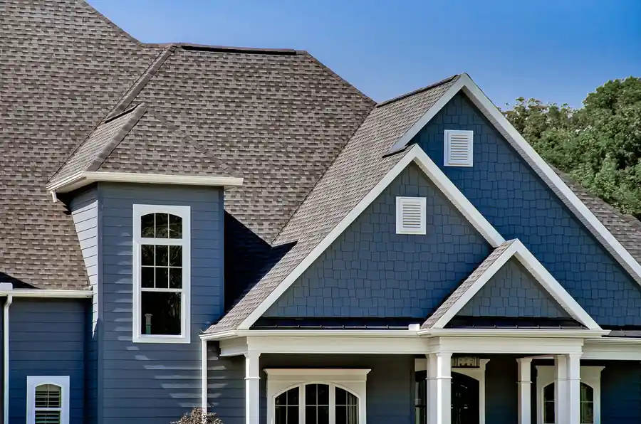 Navy lap and shake siding with white trim under a brown architectural shingle roof