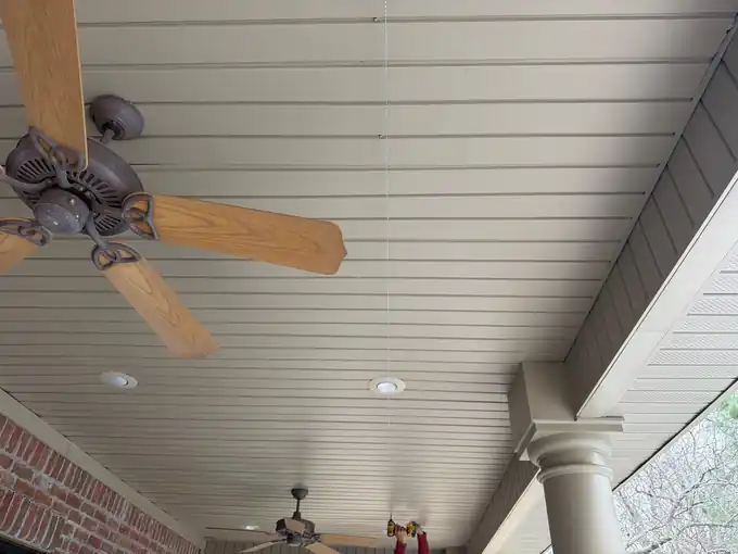 New vented soffit on a covered porch ceiling with a fan and recessed lights in Bentonville