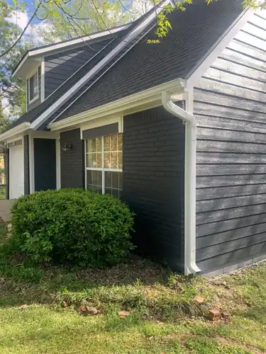 Charcoal lap siding with white trim and new white gutters on a Fayetteville home