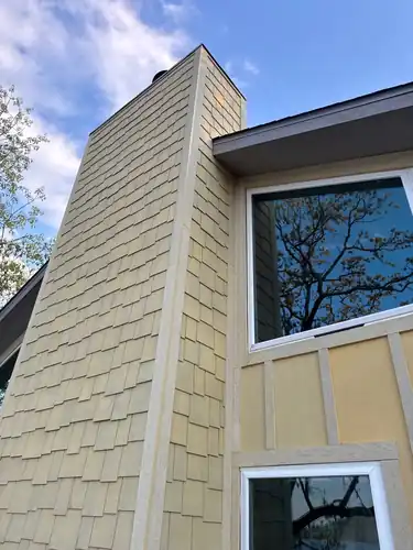 Hardie shake-accent chimney chase set against board and batten siding and large windows