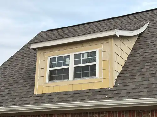 New window in a shake-sided dormer on a shingle roof